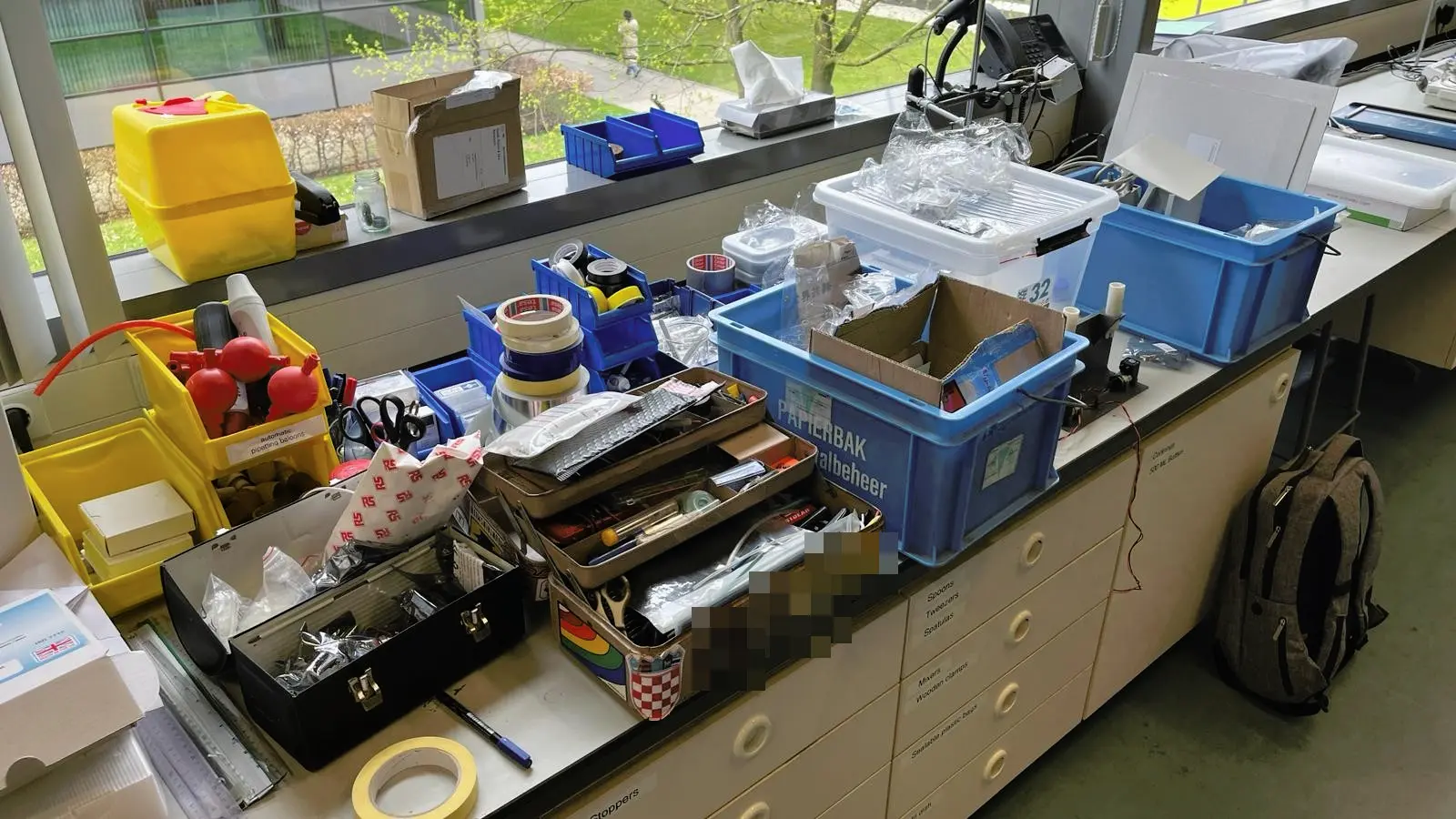 Series of toolboxes and storage containers filled with toolboxes on a laboratory work bench